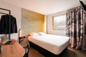 罗尼苏布瓦B&B HOTEL Paris Rosny-sous-Bois的酒店客房设有床和窗户。