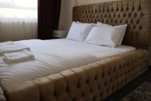 内夫谢希尔Loft Palace Suit的一张配有白色床单和枕头的大床