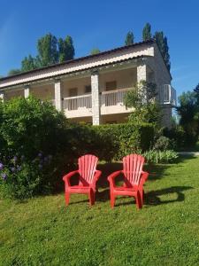 维逊拉洛梅尼Le Moulin de César的两把红色椅子坐在房子前面的草上