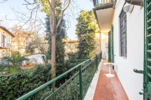 佛罗伦萨Petrarca Apartment的阳台设有绿色的围栏和树