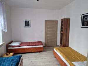 莱希纳Noclegi Leśna的一间卧室配有两张床和一个衣柜