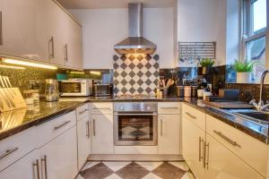 达德利DUDLEY - 1Bed - CORPORATE TRAVEL - PARKING - LONG STAYS的厨房配有白色橱柜和炉灶。