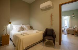 拉戈斯Casa Margô的卧室配有白色的床和椅子