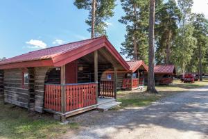 赖特维克First Camp Siljansbadet - Rättvik的小木屋设有红色屋顶和门廊