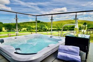 莫尔德Arbennig Luxury Lodges的观景甲板上的按摩浴缸