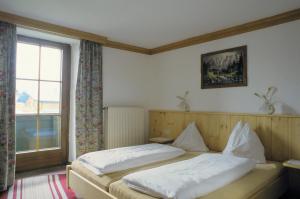 蒂罗尔州奥伯恩多夫Kaiserpension Müllnerhof的一间卧室设有两张床和窗户。