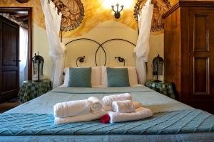 卢卡Luxury Corte Di Re Artù的一间卧室配有带毛巾的床