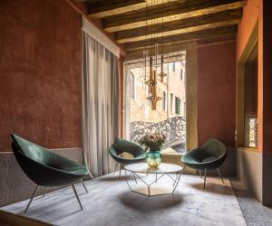 威尼斯Ninfea Luxury Suites的一间设有两把椅子、一张桌子和一个窗户的房间