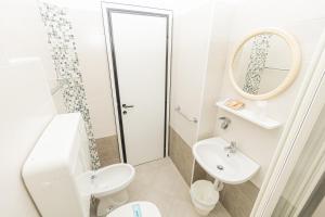 里米尼Hotel Arlino的一间带水槽、卫生间和镜子的浴室