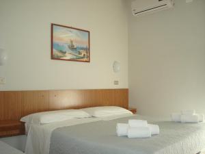 里米尼阿马尔菲酒店的卧室配有两张床,墙上挂着一幅画