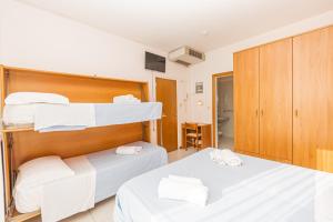 里米尼Hotel Arlino的一间卧室配有两张床和白色毛巾