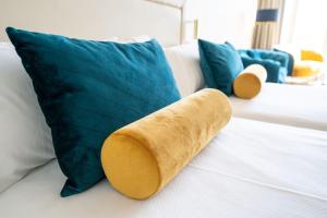 马翁Seth Port Mahón的枕头坐在蓝色枕头旁边的床上