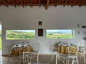 卡兰卡斯Pousada Sal da Terra的客房设有2张桌子和椅子以及窗户。