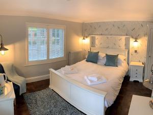 MoulsfordFerryman`s Cottage at The Beetle & Wedge的卧室配有白色的床和2条毛巾