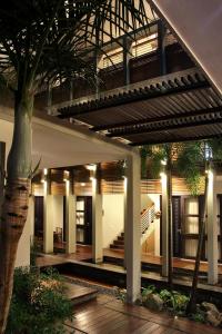 玛琅舒适精品旅馆的一座有楼梯和树的建筑的中庭