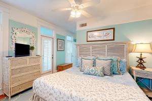 圣西蒙斯岛True Knot Cottage的一间卧室配有一张带吊扇的床和一台电视。