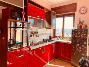 那不勒斯Napoli Centro的一间厨房,配有红色橱柜和大窗户