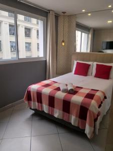 圣保罗Apartamento no centro de São Paulo的一间卧室配有一张带 ⁇ 子毯子的床
