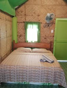 BuruangaLorenza's Cottage 1的一间卧室配有一张床,床上有毛巾