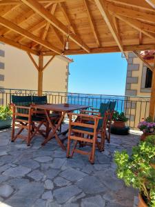 Agios Ioannis KaspakaStudios Edem的海景露台上的一张木桌和椅子