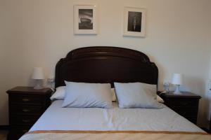 里贝拉Piso da Horta en Aguiño, Ribeira, Galicia的一间卧室配有一张带2个床头柜的大床