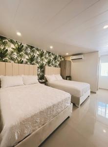 圣安德烈斯Oasis Hotel的一间卧室设有两张床和壁画墙