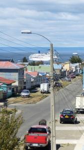 蓬塔阿雷纳斯Hostal Host Patagonia的近海道路上带有汽车的街灯