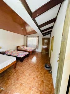 希门尼斯港Casa Nativa CR的客房设有两张床,铺有木地板。