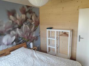 GlovelierChalet - Le Champ des Perches, Berlincourt的一间卧室配有一张床和一堵带花卉壁画的墙壁