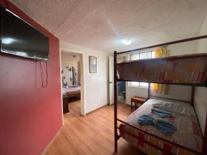巴尼奥斯Hostal los Andes的一间卧室设有一张双层床和一台平面电视。
