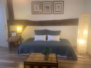 MardorMaison Mard'Or Chambre Forêt的一间卧室配有一张带两个枕头和一张桌子的床。