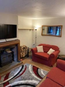 普尔伯勒Pieman's Cottage - Pulborough, West Sussex Cottage - sunny courtyard的客厅配有红色沙发和平面电视
