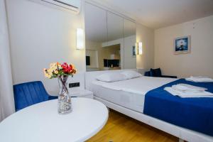 巴统Orbi City Sea View - Special Category的一间卧室配有一张床和一张花瓶桌子
