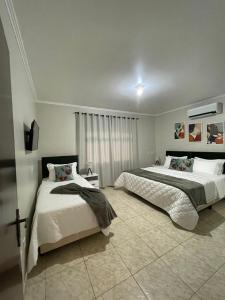 波梅罗迪Recanto Wunderwald Casa Pomerode的一间卧室设有两张床和窗户。