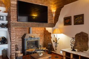埃武拉Casa da Ti´Lola的客厅设有壁炉和平面电视。