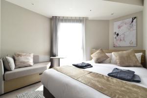 大阪Hotel Cordia Osaka Hommachi的一间卧室配有一张床、一张沙发和一个窗口