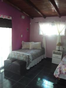马拉圭Nuestro Hogar的一间卧室配有一张床和紫色的墙壁