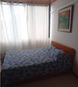 Puerto ViejoCondominio Victoria Real - Apartamento 202的一间卧室配有床和带窗帘的窗户