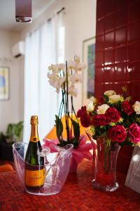 卡塔尼亚AmoCatania Apartment的一瓶香槟和一瓶花在桌子上