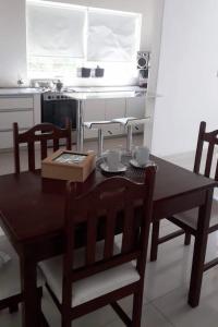 圣萨尔瓦多德朱Casa kukycita的厨房配有木桌、椅子、桌子和桌子。