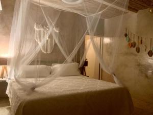 阿卡普尔科Casa de las Olas Surf & Beach Club的卧室配有带白色窗帘的天蓬床