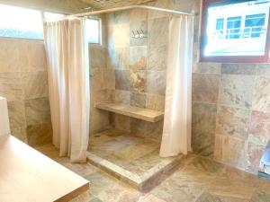 阿卡普尔科Casa de las Olas Surf & Beach Club的带淋浴和浴帘的浴室