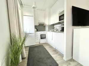 坦佩雷Tammer Huoneistot - City Suite 1 - Sauna, Balcony & Free parking的厨房配有白色橱柜和黑色地毯。