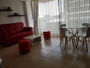 危地马拉Apartamento Reforma Ciudad de Guatemala的客厅配有红色的沙发、桌子和椅子