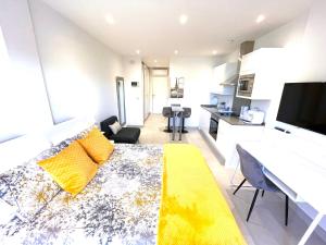 直布罗陀Gibraltar Central Suites的一间带黄色沙发的客厅和一间厨房
