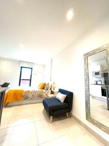 直布罗陀Gibraltar Central Suites的一间卧室配有一张床、镜子和椅子