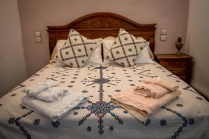 非斯Dar El Karam Fez的一张带两条毛巾和枕头的床