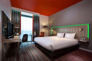 曼彻斯特曼彻斯特中心丽笙公园酒店的酒店客房设有一张大床和一张书桌。
