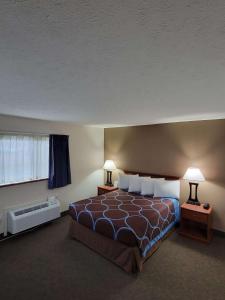 格兰德岛格兰德岛速8酒店的一间卧室配有一张带两盏灯的床和一扇窗户。