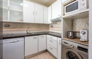 Benalmadena CostaSurf house的厨房配有白色橱柜、洗衣机和烘干机
